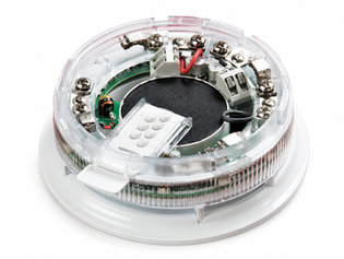 Apollo Discovery Category O Sounder VAD Base with Isolator 45681-700, featuring an integrated audible sounder, white-flash visual alarm device, detector mounting base, and short-circuit isolator for addressable fire alarm systems.