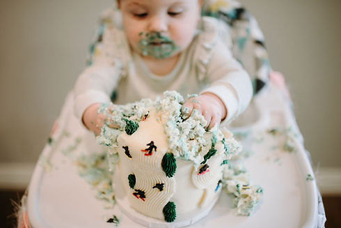 Baby smashing a first birthday cake