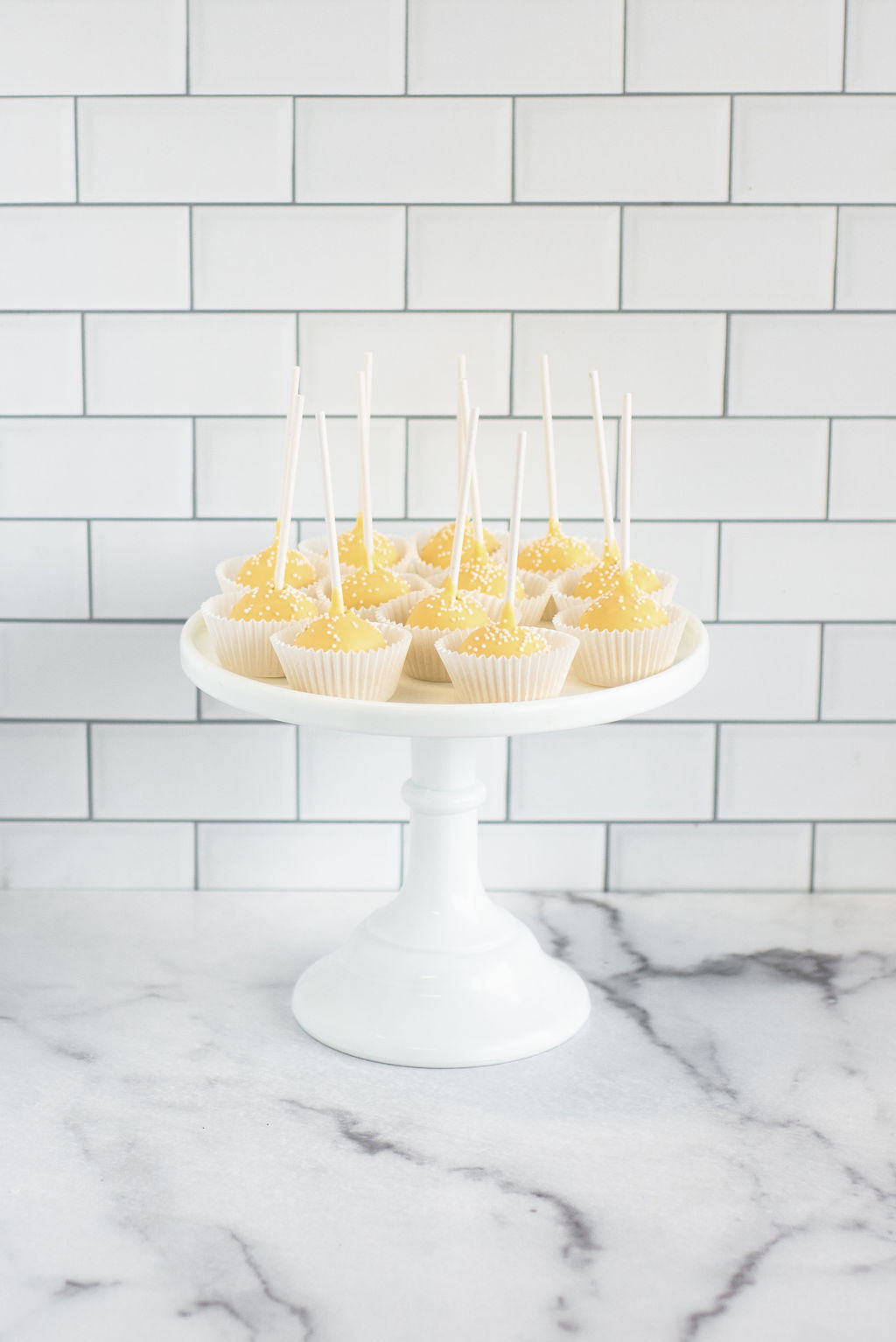Lemon flavored cake pops with a pastel yellow vanilla chocolate shell
