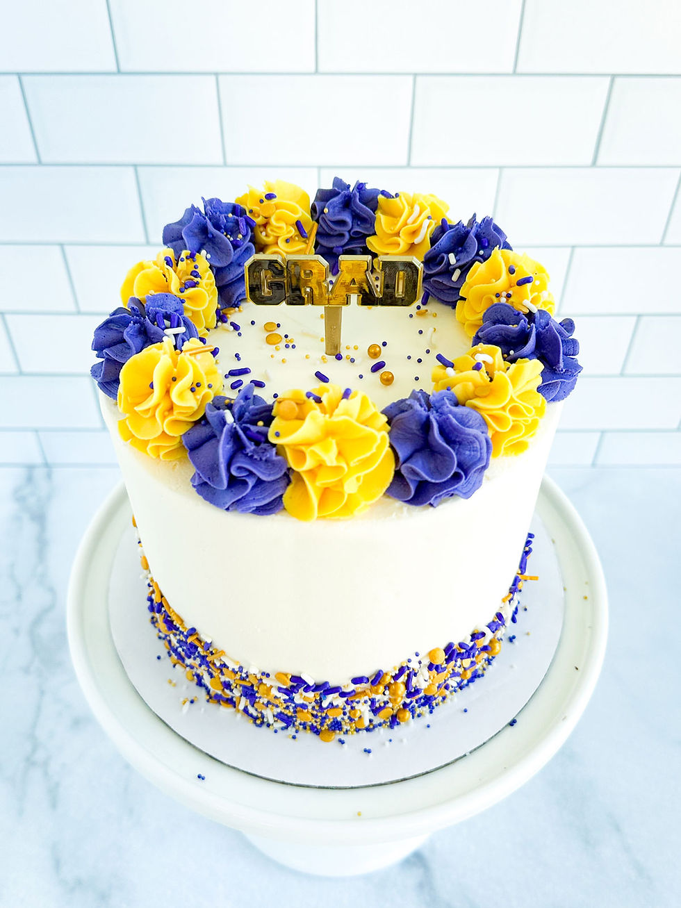 Thumbnail: Custom graduation cake in purple and gold buttercream frosting from seatown sweets