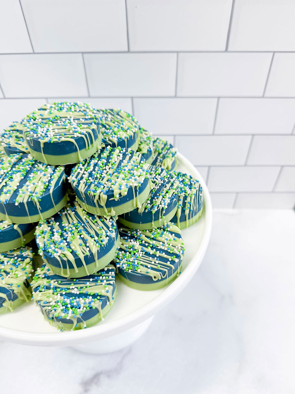 Seahawk themed chocolate dipped Oreo cookies in Seahawk themed blue and green colors.