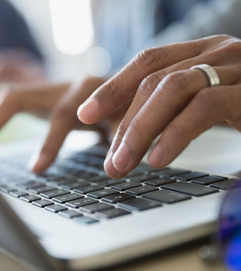 Man Typing on a Laptop