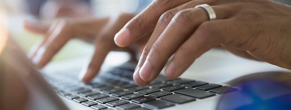 Man Typing on a Laptop
