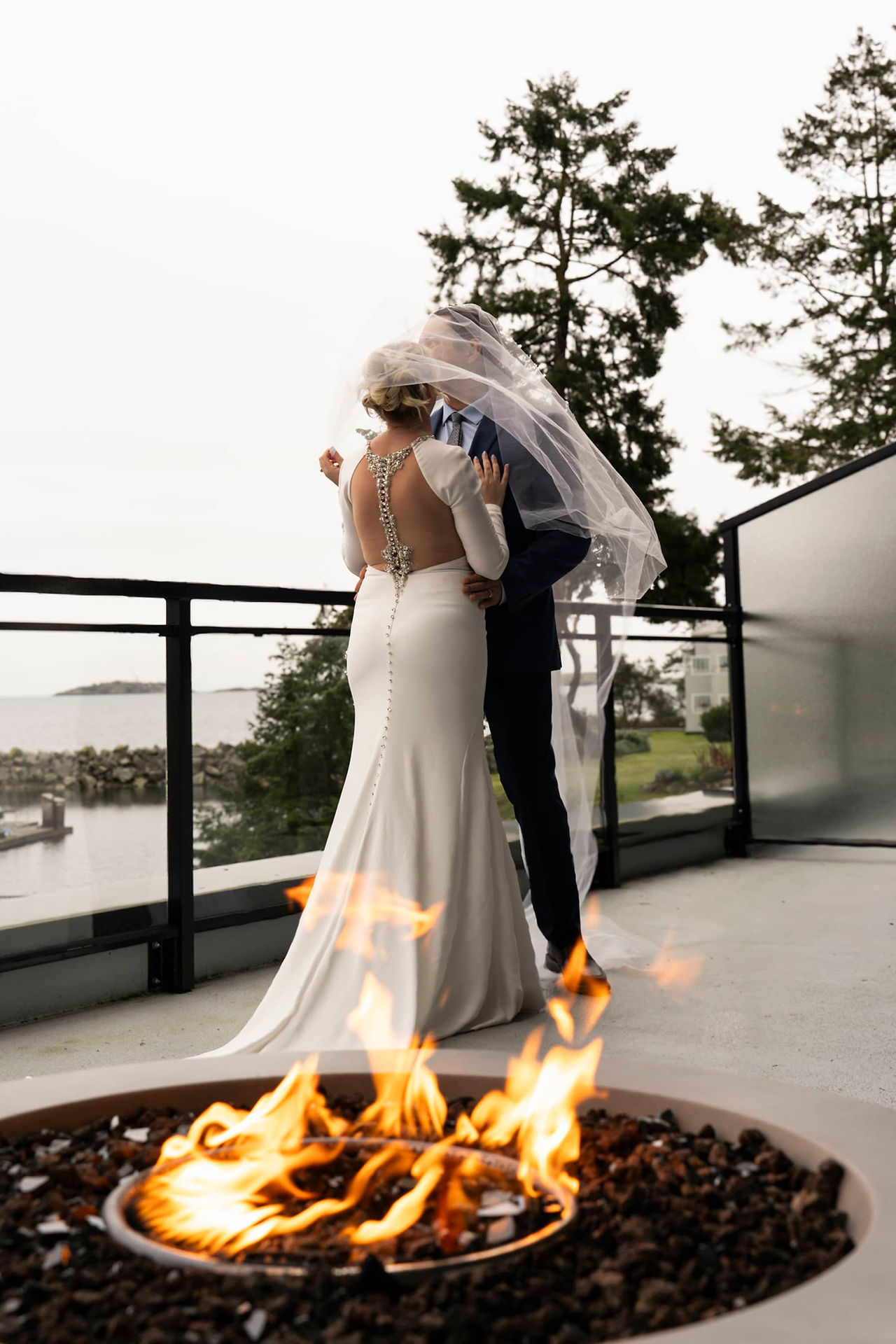 Newlyweds pose by the fireplace inside Nanoose Bay Cafe's charming indoor venue