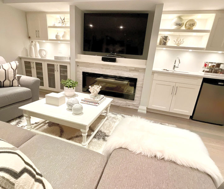 Built-ins with fireplace and quartz countertops make this lower level living space feel like the main floor. Design and decorating by Caroline Loon Designs.
