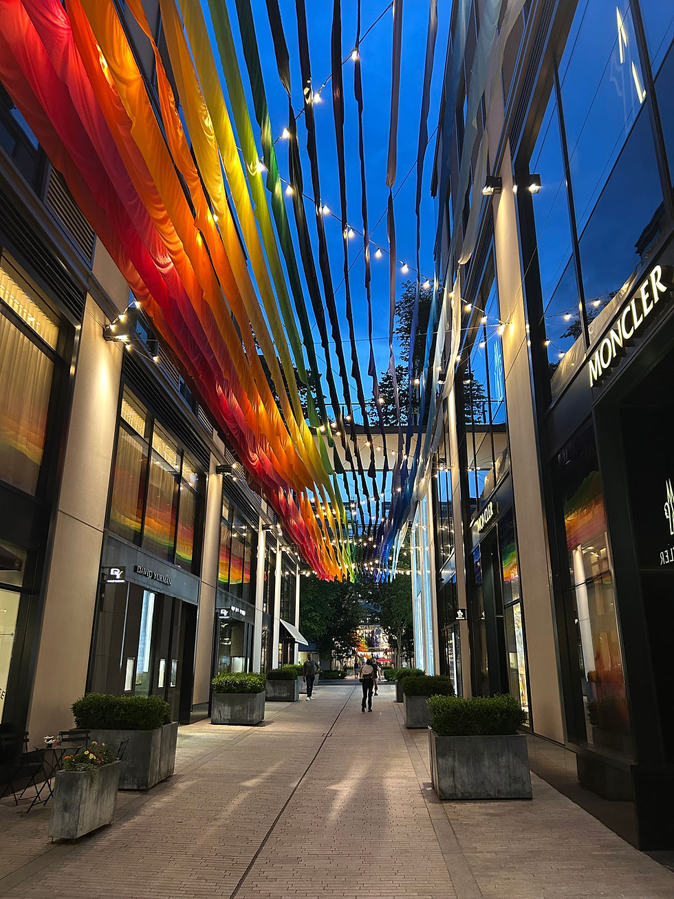 Rainbow-colored banners between buildings in a shopping center
