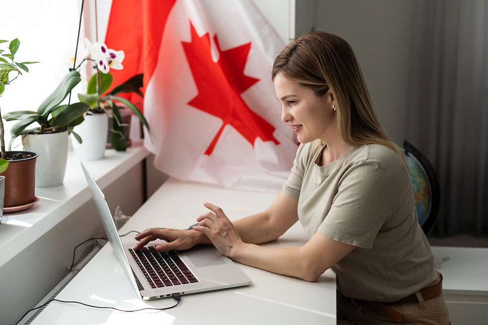A woman working on a laptop in an office space with a Canadian flag.