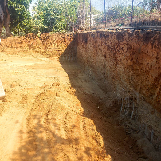 Excavation site with exposed soil layers for foundation preparation.