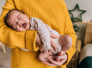 baby in a side hold while crying