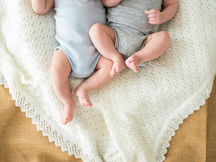 twin newborn legs laying on a blanket
