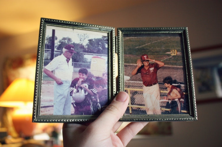 hand holding two old photos in a frame