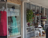 storefront with mannequins in formal gowns