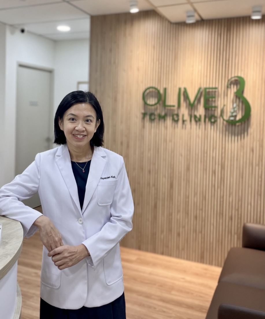 Physician Koh Soo Hoon smiling at the reception of Olive3 TCM Clinic
