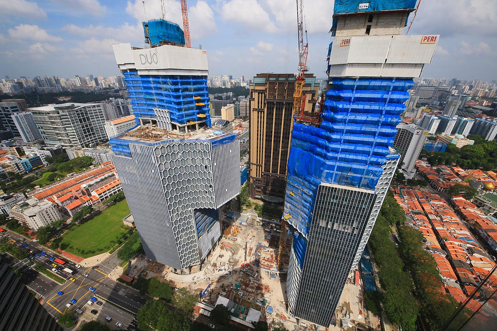 Aerial view of twin-tower construction progress in Singapore.