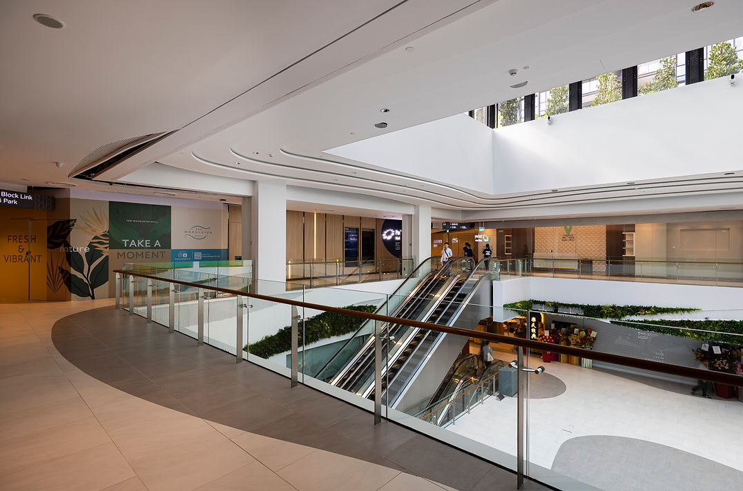 Interior atrium view of an integrated residential and retail development in Singapore.