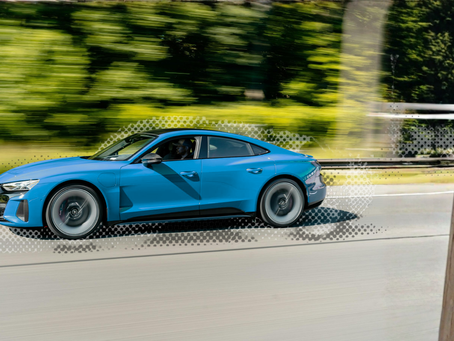 A fast muscle car soars by, operated by a teenage boy.