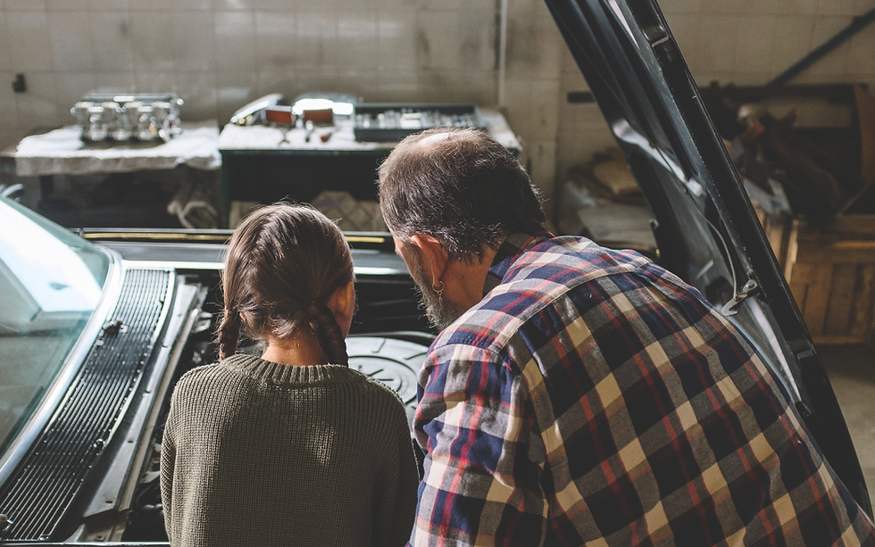 A business founder shows his daughter one of the company trucks