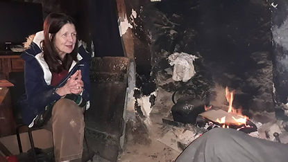 Two figures in an old stone cottage, sharing quiet presence across generations