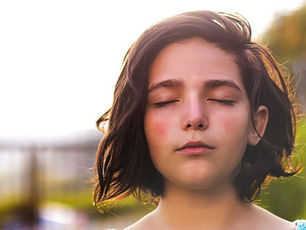 Une jeune femme les yeux fermés concentrée sur sa respiration