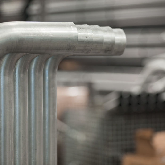 Mandrel-bent stainless exhaust tubes lined up in manufacturing facility