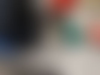 Person measuring a metal pipe with a tape measure on a workshop table. Tools and a green metal bracket are nearby. Casual setting.