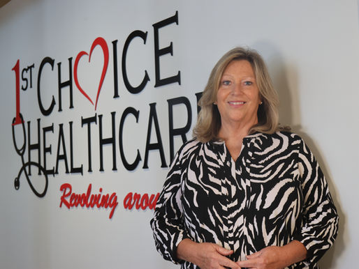 Health Center CEO stands in front of logo'd wall