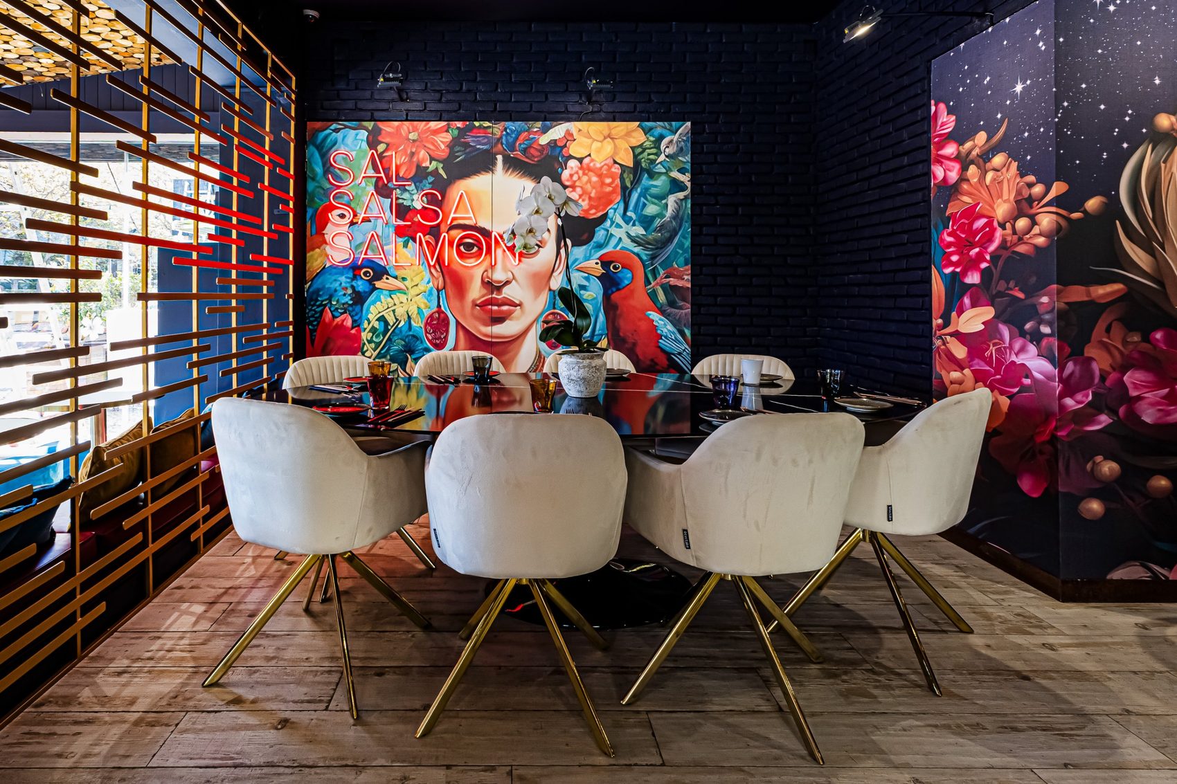 Sala reservada do restaurante com mesa de seis e mural com néon