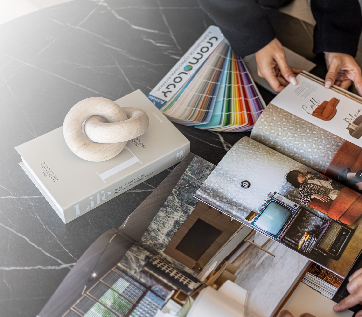 Mesa de reunião com catálogos abertos e leque de cores