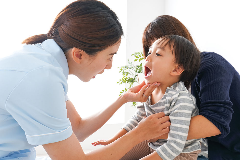 歯科スタッフにお口を見せる子どもと保護者