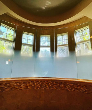 Residential bathroom, 5 large glass divides the shower area from the sink area. Each glass pane has a custom gradient design. no live seams. fully covered glass