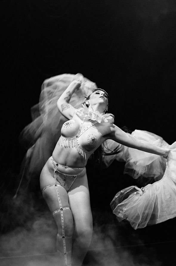 A showgirl under smoky stage lights, shimmering with quiet melancholy — nearlism photography