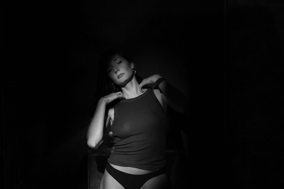 A fleeting smile on her face, fragile against the dim light — nearlism photography