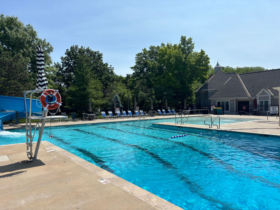 Sunny outdoor pool with slide and diving board