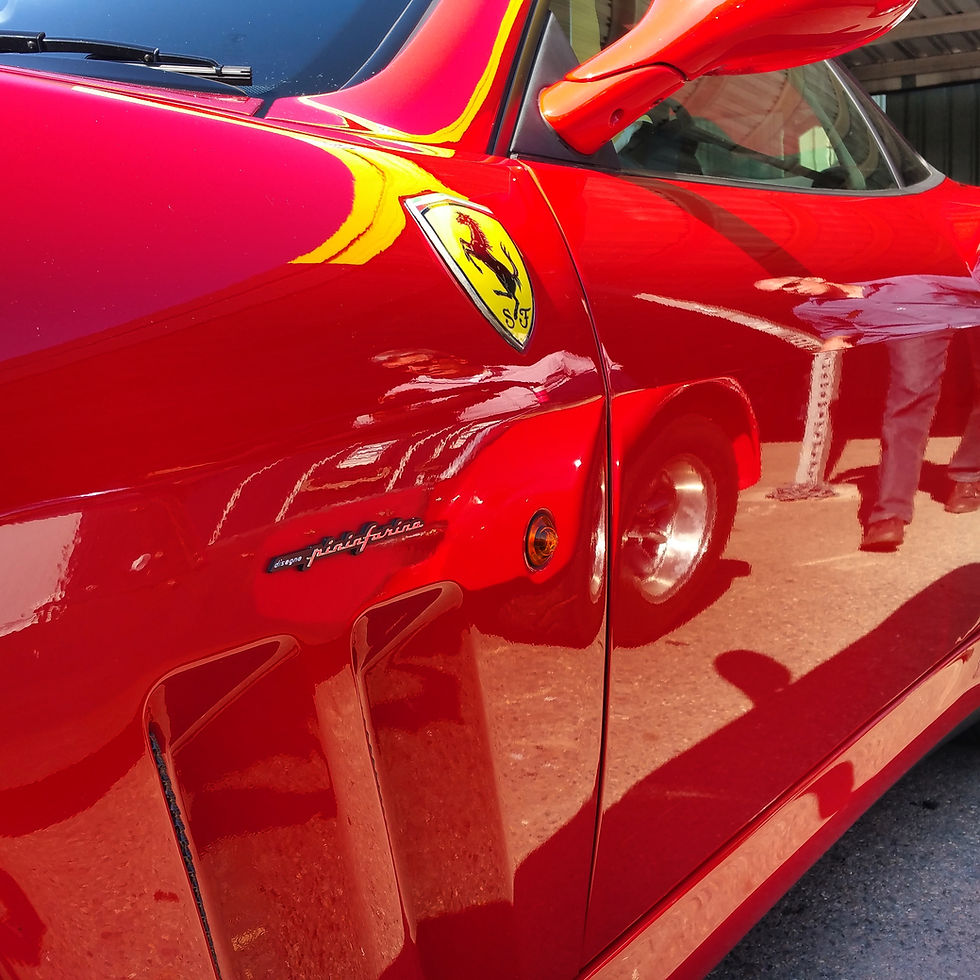 Close-up view of a car hood with glossy black graphene coating reflecting sunlight