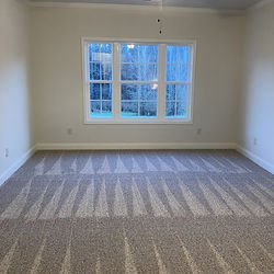 Cleaned empty bedroom with vacuumed carpet lines