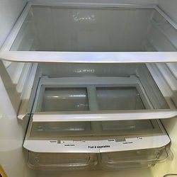 Empty refrigerator with clean glass shelves and drawers.