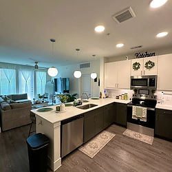 Clean modern kitchen with white counters and dark cabinets