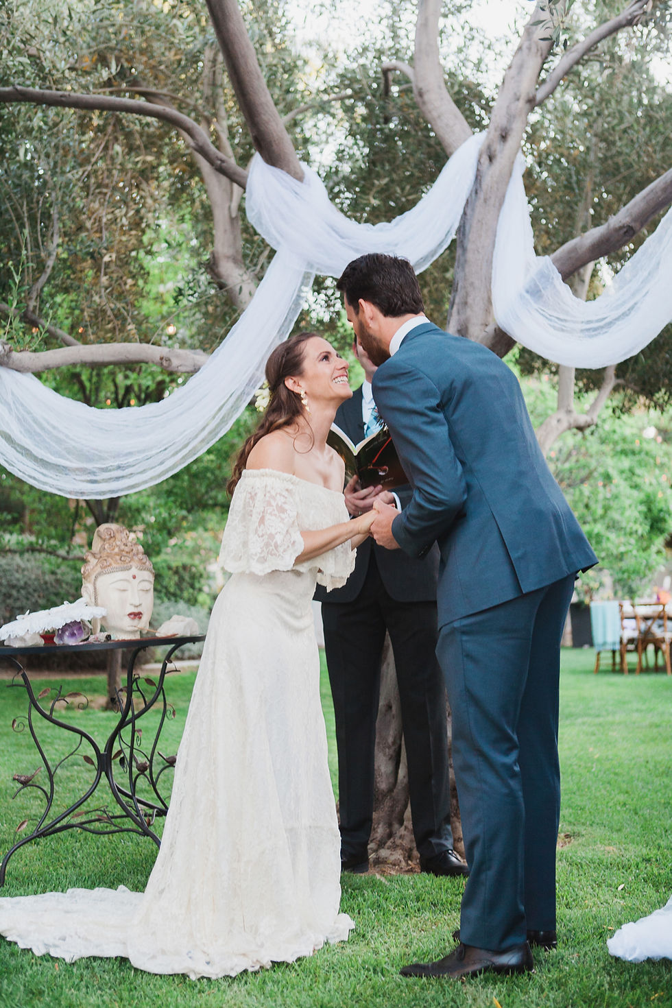 Bride and Groom hold hands and smile at each other