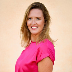 Portrait der Fotografin Jenni Kurz - Blonde, lächelnde Frau vor Terracotta Wand in strahlend pinker Bluse; Sommer in Kroatien, Fotografie in Pula in Istrien
