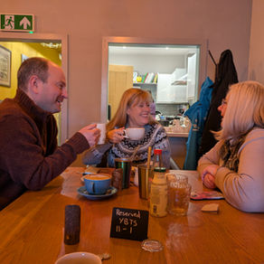 Three people drinking a cuppa and chatting.
