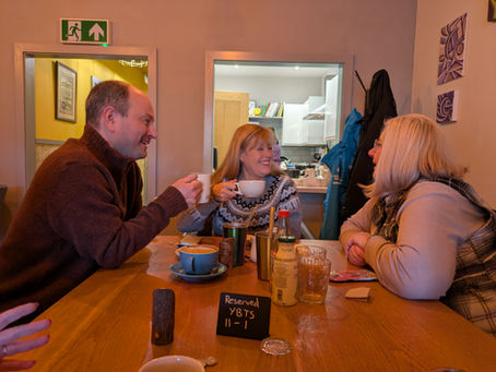 Three people drinking a cuppa and chatting.