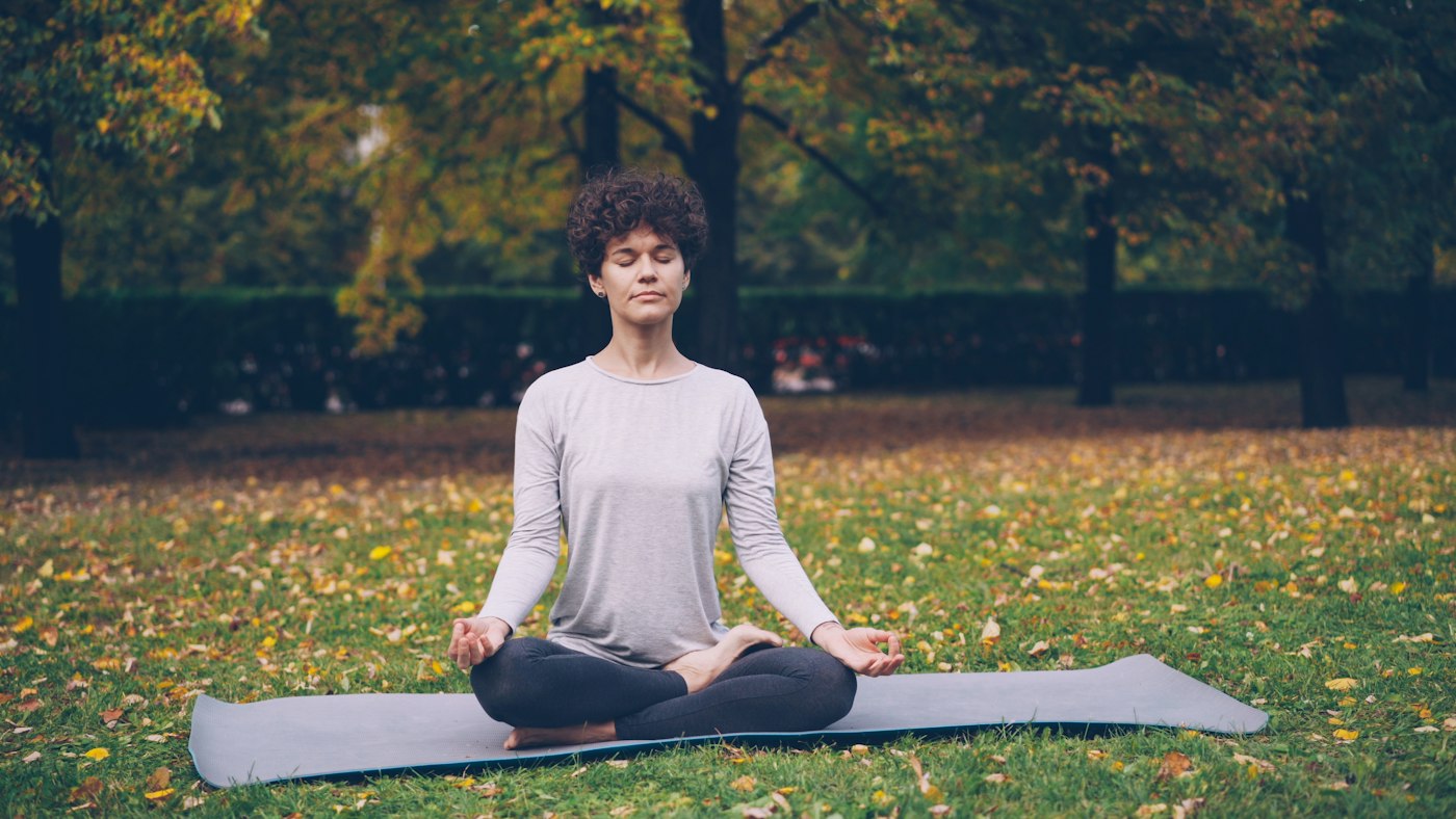 Real editorial photograph of woman meditating outdoors. Cover for Mantra Meditation Without the Mystique: Finding a Word That Grounds You