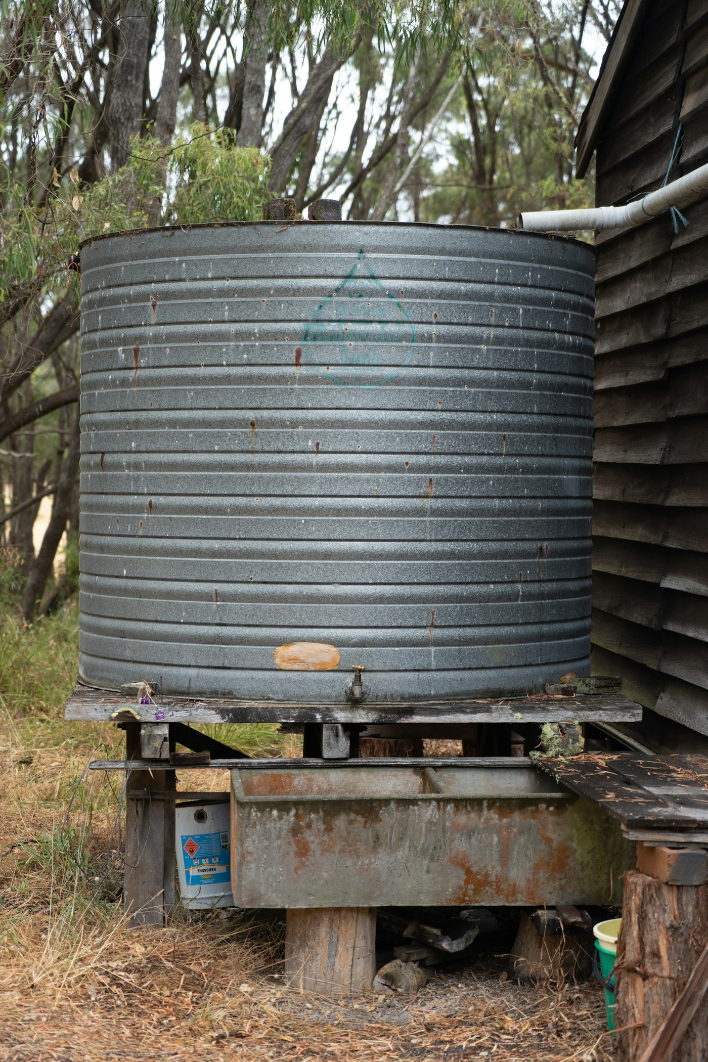 Documentary photograph: Rainwater barrel near cabin. Cover for The Repair Café: Learning While Fixing
