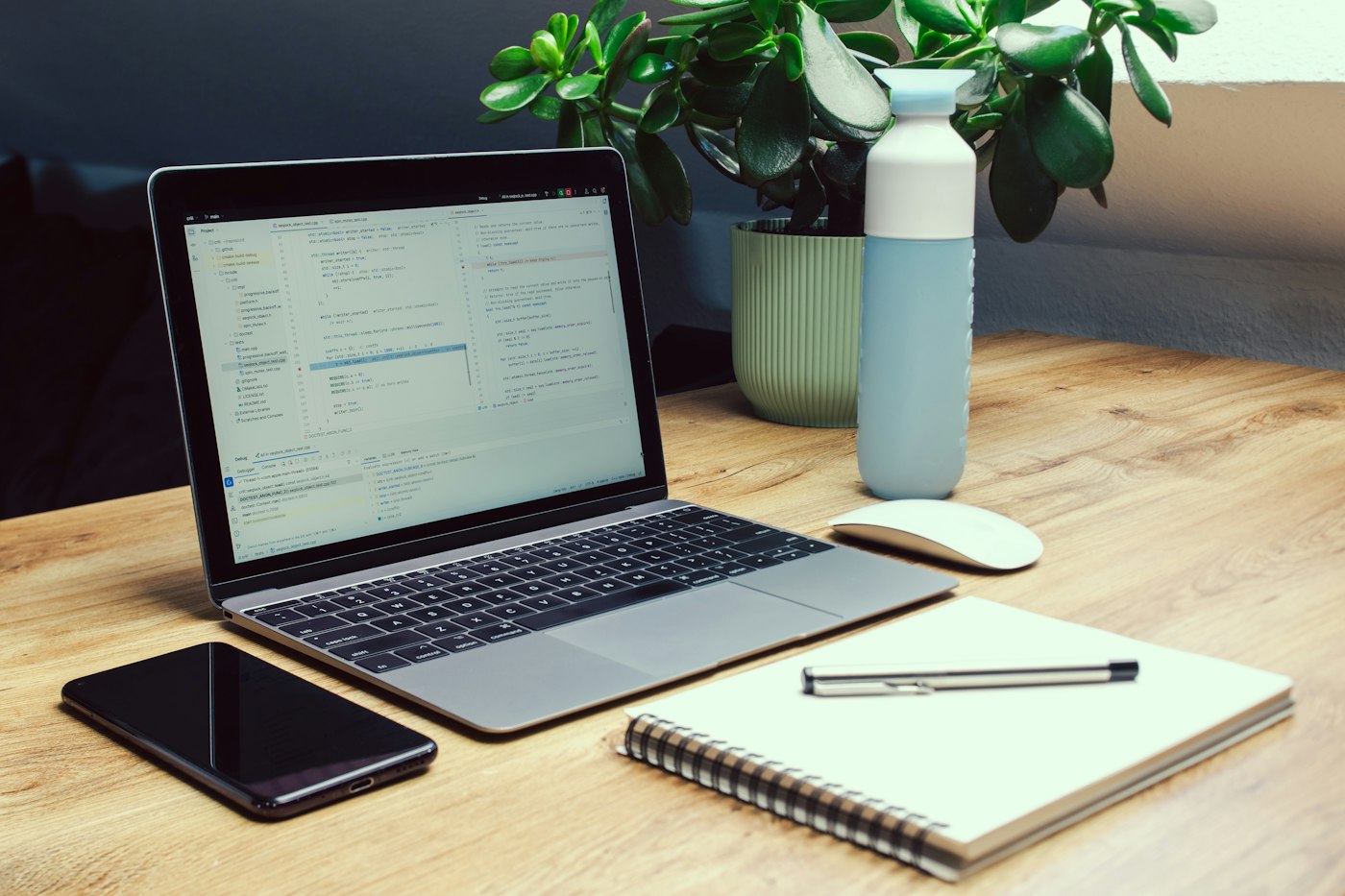 Real editorial photograph of laptop phone notebook and reusable water bottle. Cover for Offline Maps and the Freedom to Wander Responsibly