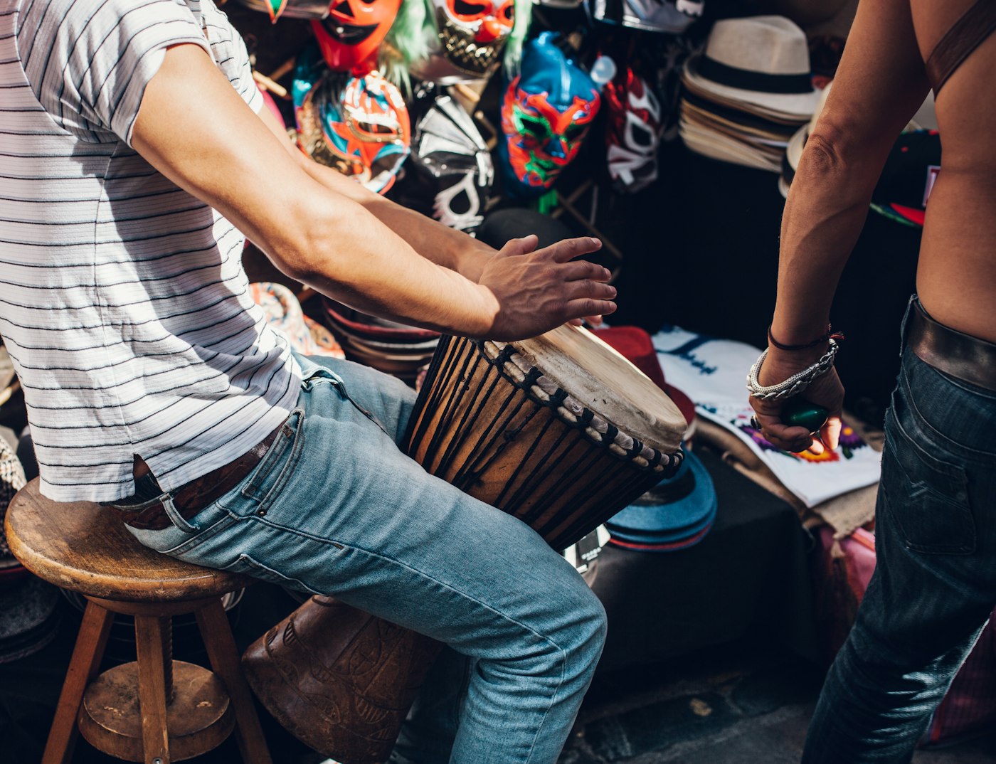 Real editorial photograph of musician playing djembe. Cover for Drum-Led Meditation: Find Focus in a Steady Pulse