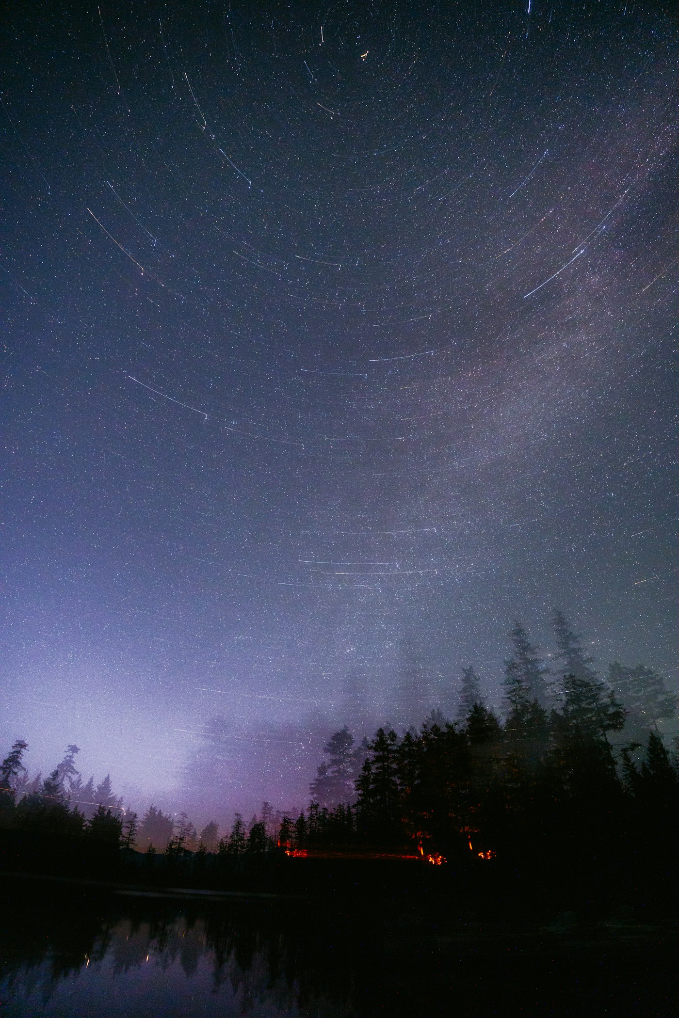 Real editorial photograph of stars over a lake. Cover for The Soundscape of a Better Night