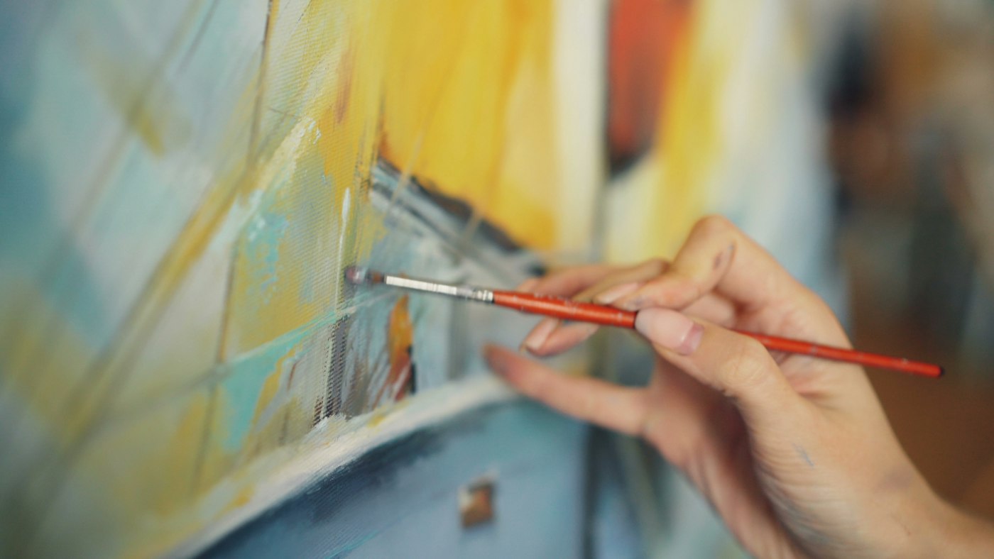 Real editorial photograph of artist painting a colorful canvas. Cover for Blind Contour Drawing: Learning to See Again