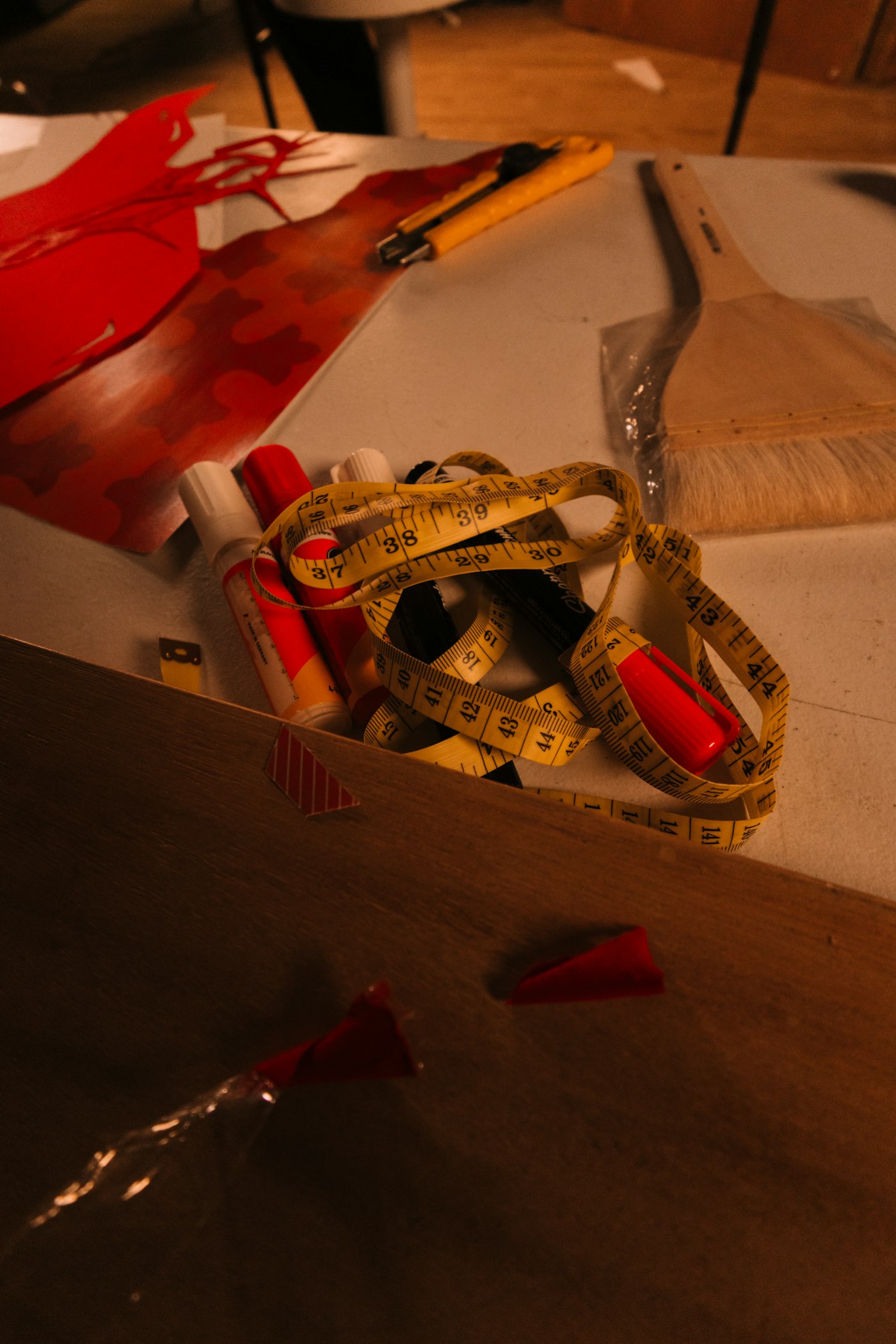 Real editorial photograph of handmade crafting supplies including tape measure and paint. Cover for The Handmade Zine: A Tiny Magazine With a Big Voice