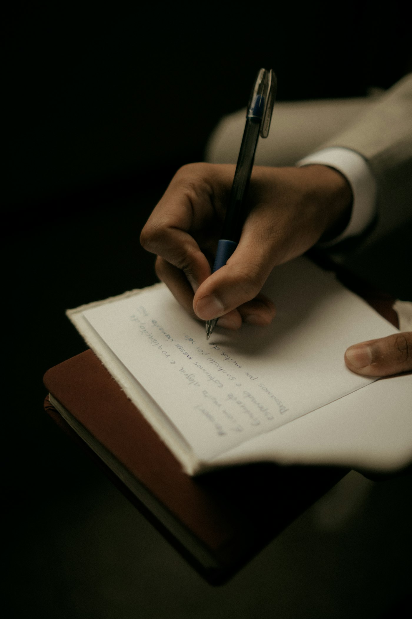 Real editorial photograph of journaling in a notebook. Cover for Audio Journaling for People Who Hate Writing