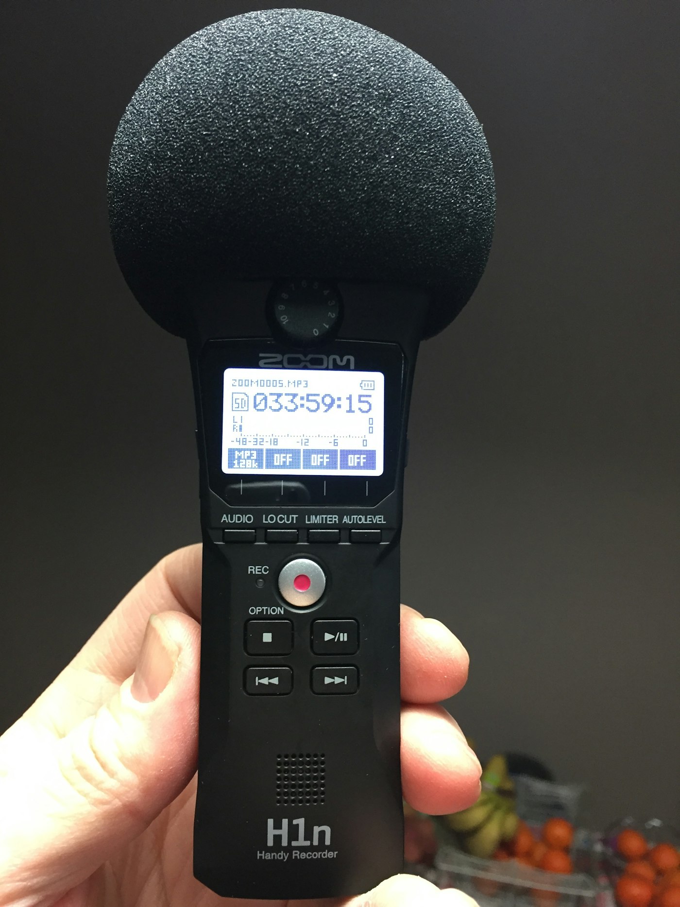 Real editorial photograph of digital audio recorder in hand. Cover for Field Recording: Collecting a Place in Sound
